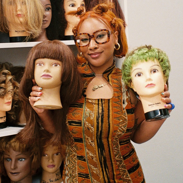 Woman holding mannequin heads